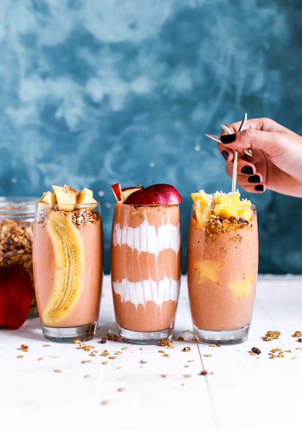 Three fresh juice glasses with fruit and grain